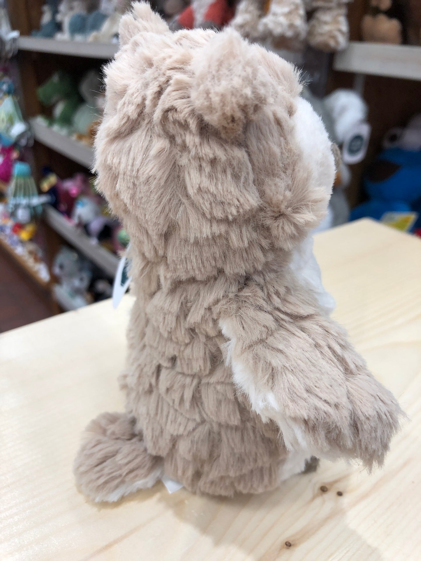 Soft, fluffy Mary Meyer Puttling Owl plush toy sitting on display, showing its fuzzy beige feathers and cute round shape