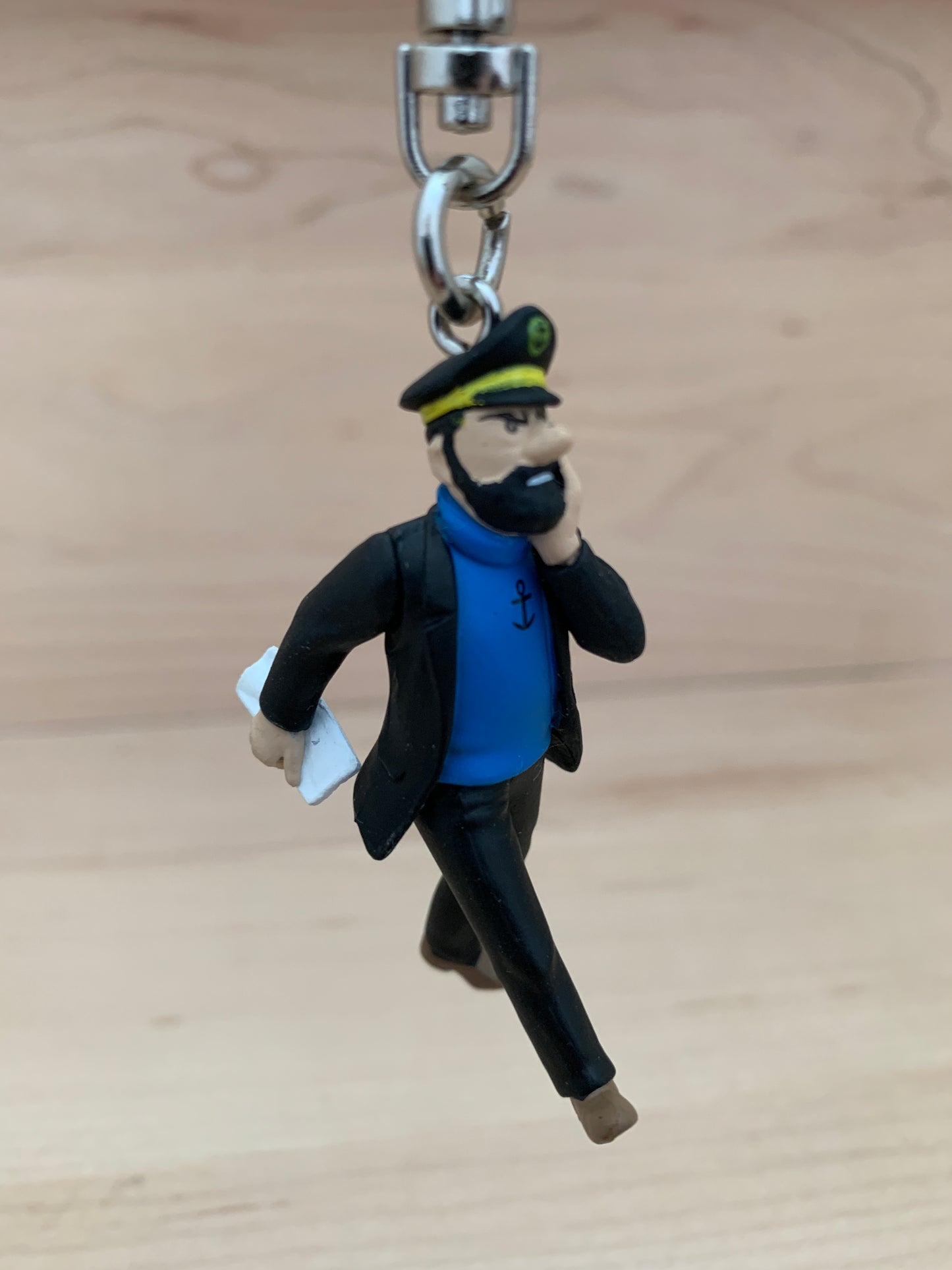 Captain Haddock keychain figurine reading newspaper, wearing blue shirt and black coat, 6cm Tintin collectible