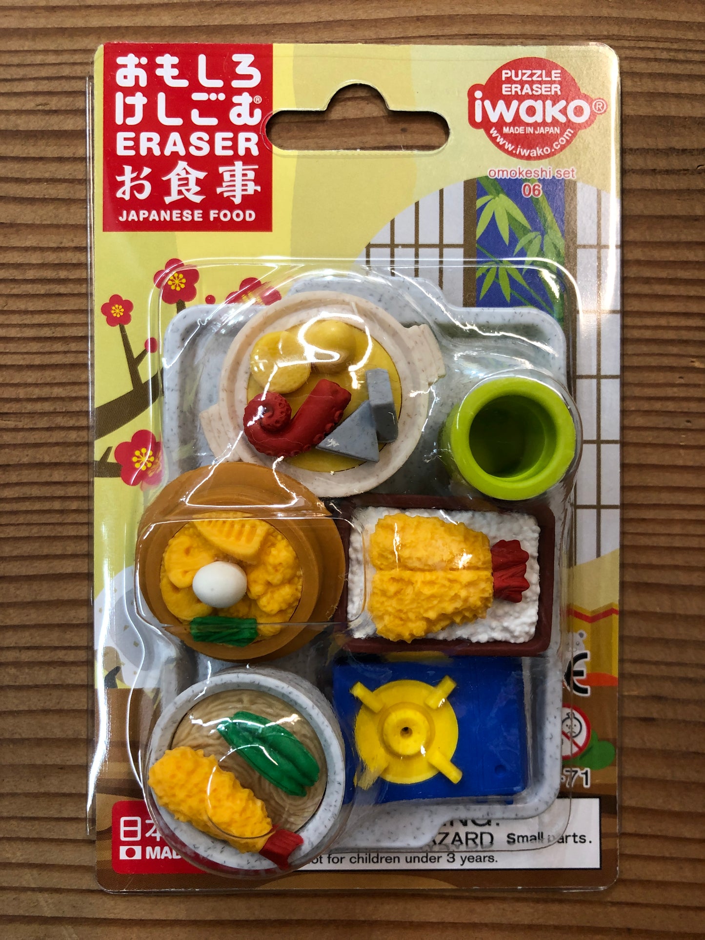 Japanese food eraser set featuring miniature tea cup, sushi, rice dishes, and tray on colorful packaging with cherry blossom design