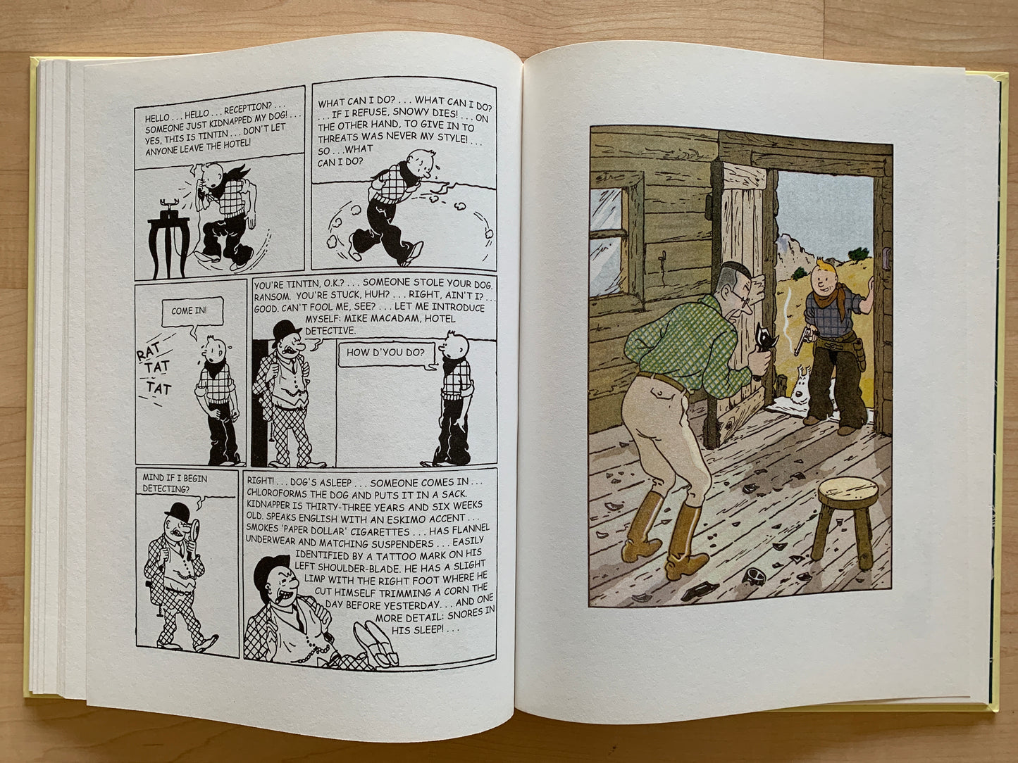 Open pages of Tintin in America comic, showing black and white panels and one color panel from Hergé's adventure series