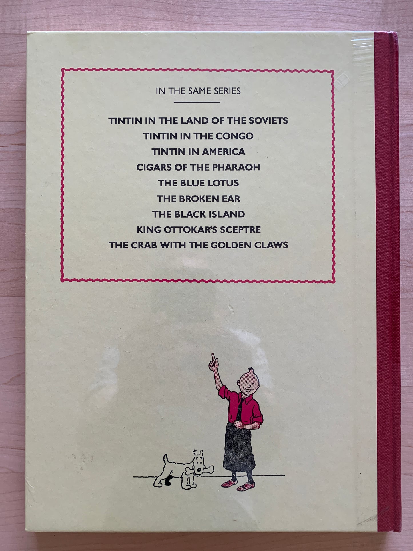 Back cover of Tintin book listing other titles in series, with illustration of Tintin and Snowy at bottom