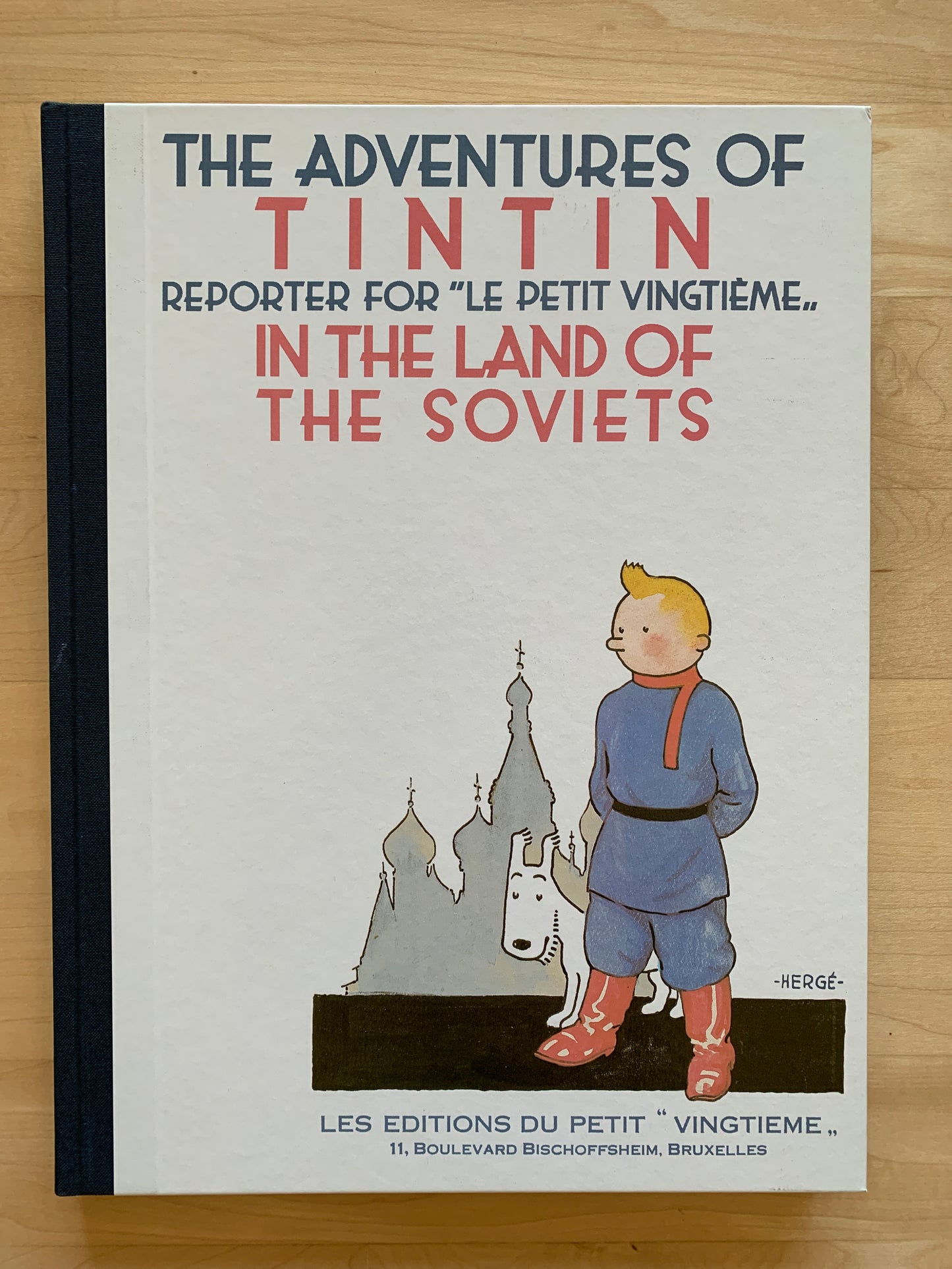 Book cover of "The Adventures of Tintin: In the Land of the Soviets" showing Tintin and Snowy with Russian architecture
