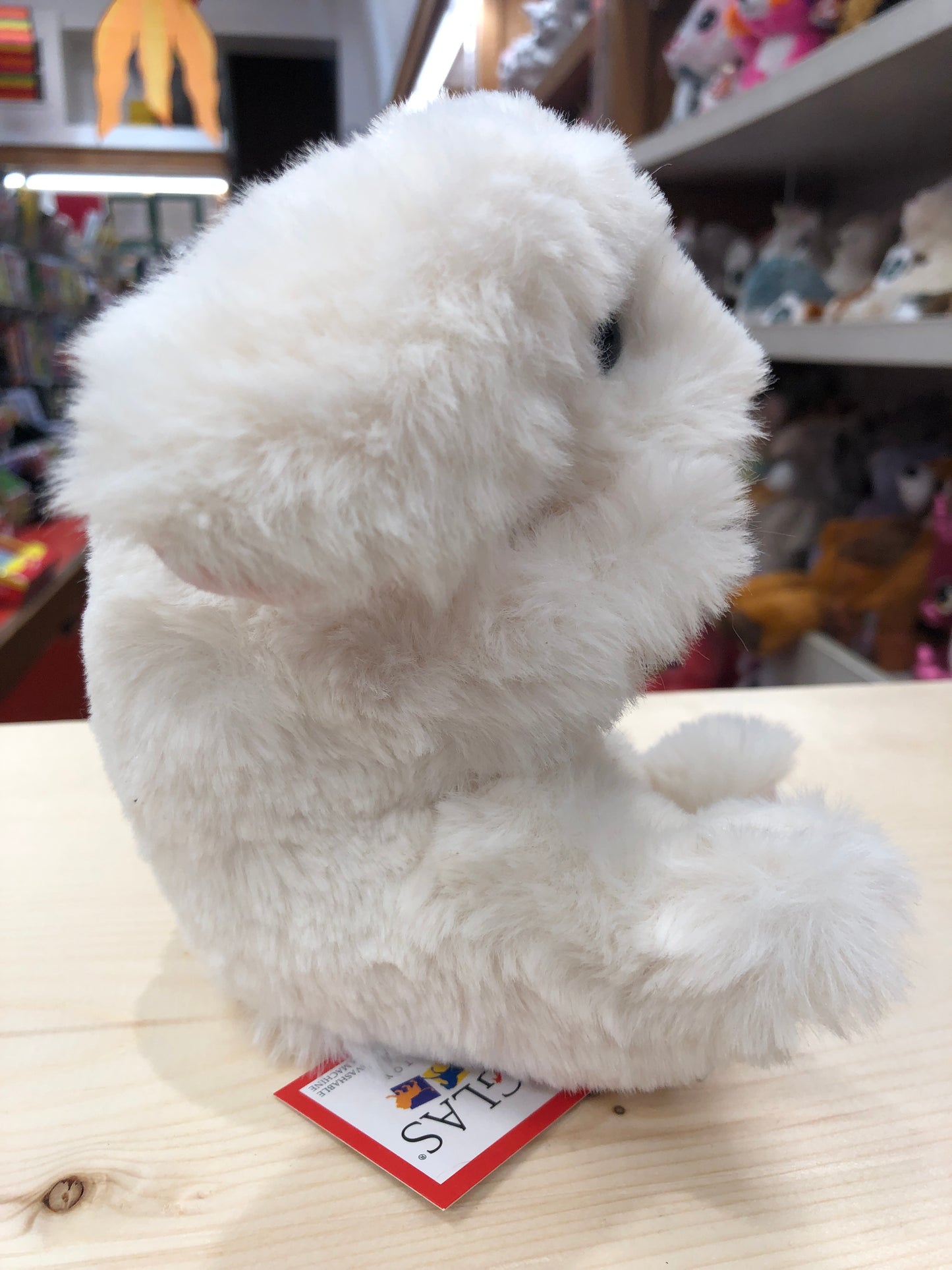 Soft cream Douglas Lil' Handful bunny plush toy sitting upright on display, showing fluffy texture and small size