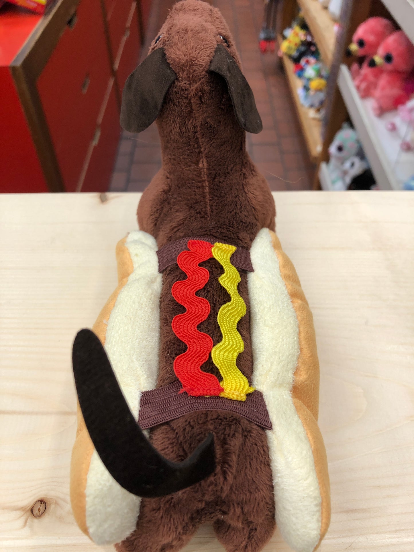 Folkmanis Hot Dog finger puppet with brown plush dachshund in removable bun, colorful condiment details on back, movable head and tail