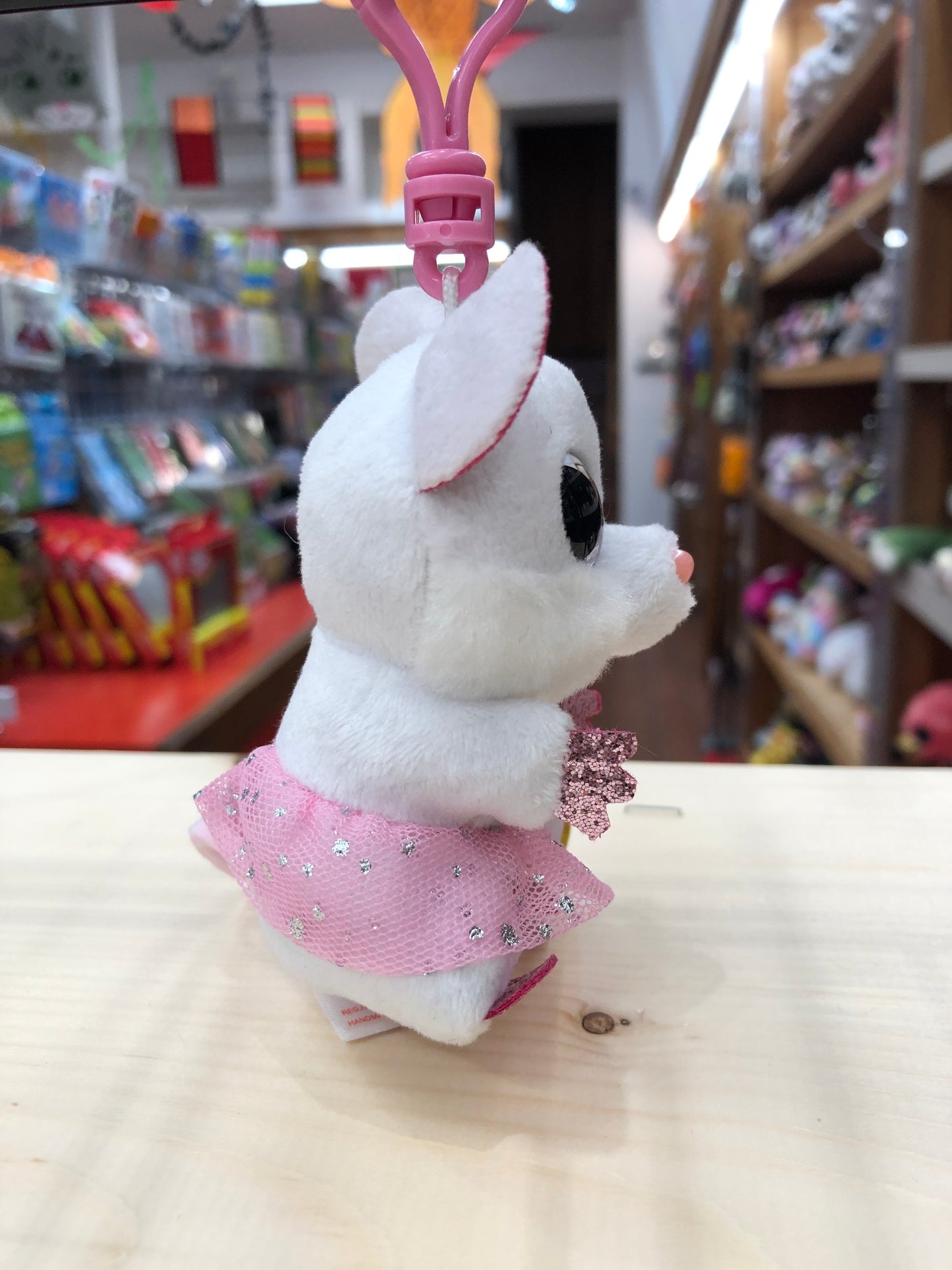 Ty Beanie Boo Nina white mouse plush clip wearing sparkly pink tutu, displayed in toy store with clip attachment