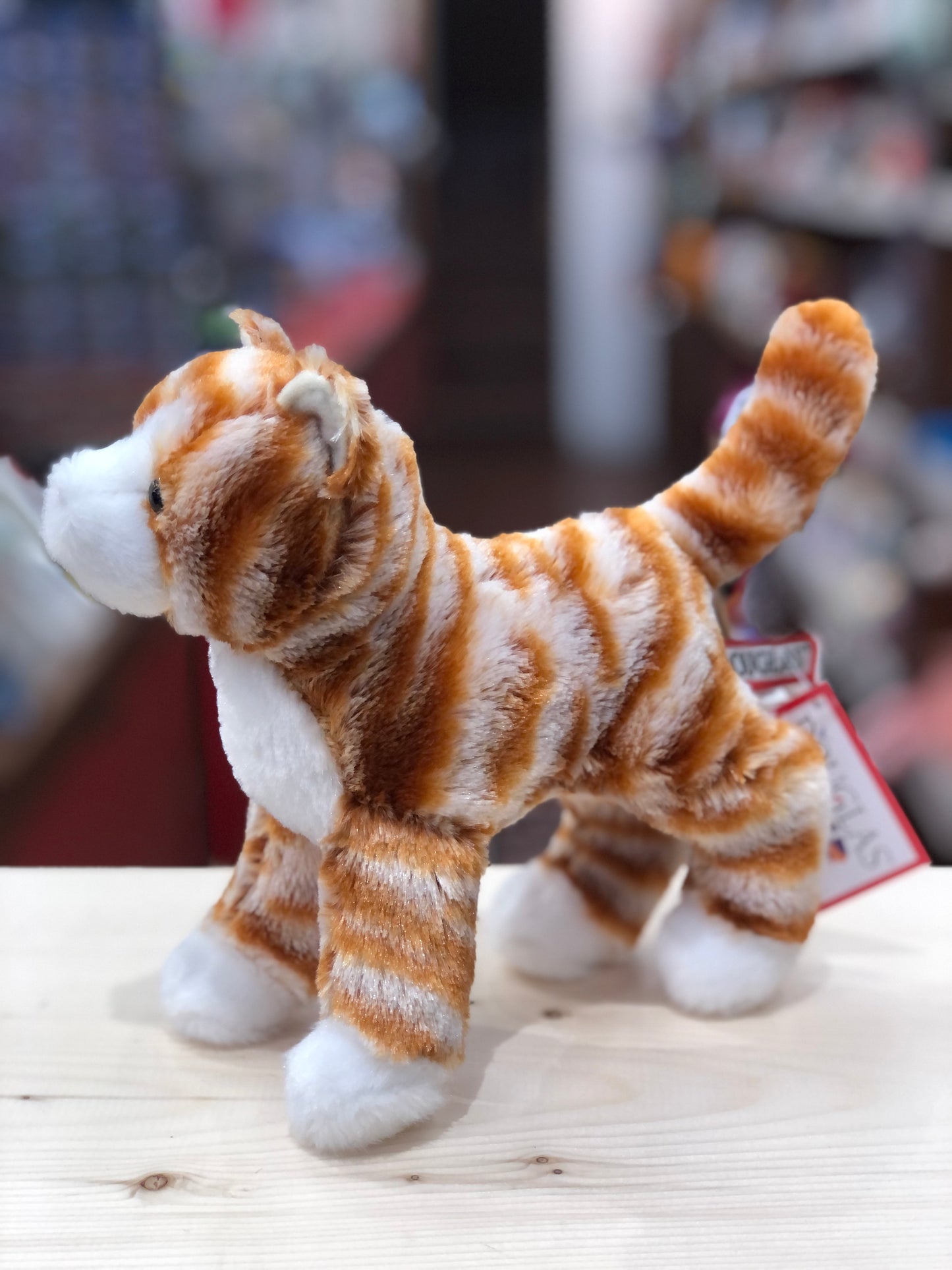 Soft orange striped cat plush toy standing alert with white paws and belly, ready for adventure and play