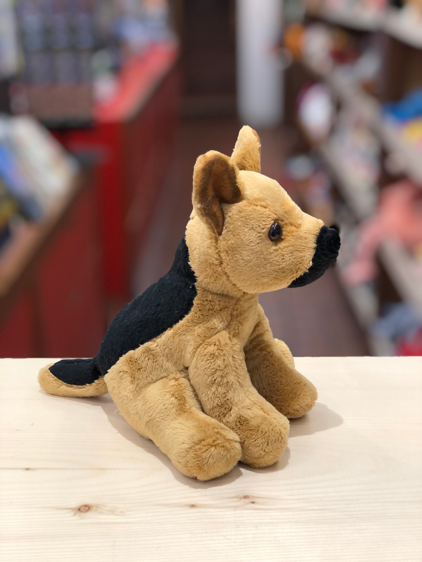 Cute 6-inch German Shepherd plush toy, Prince, with alert expression and oversized ears, sitting on wooden surface