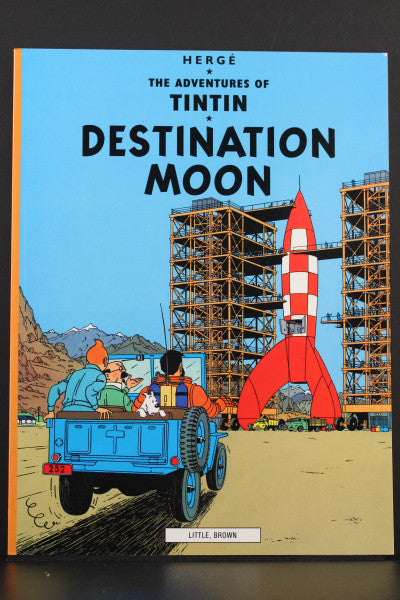 Cover of Tintin's "Destination Moon" book showing rocket launch site with characters in jeep approaching