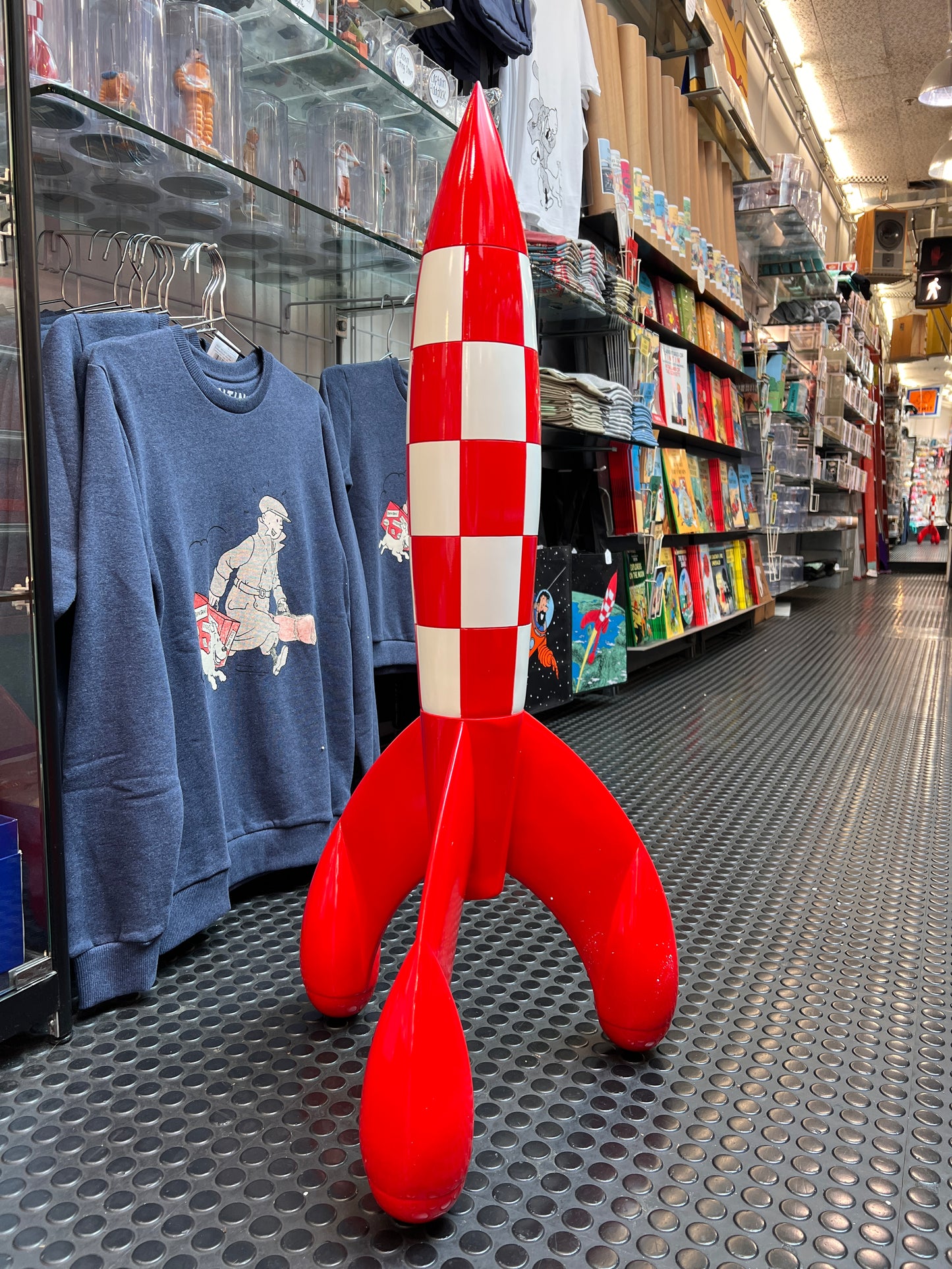 Tintin Moon Rocket model in store, 90cm tall, red and white checkered design, next to Tintin merchandise and books