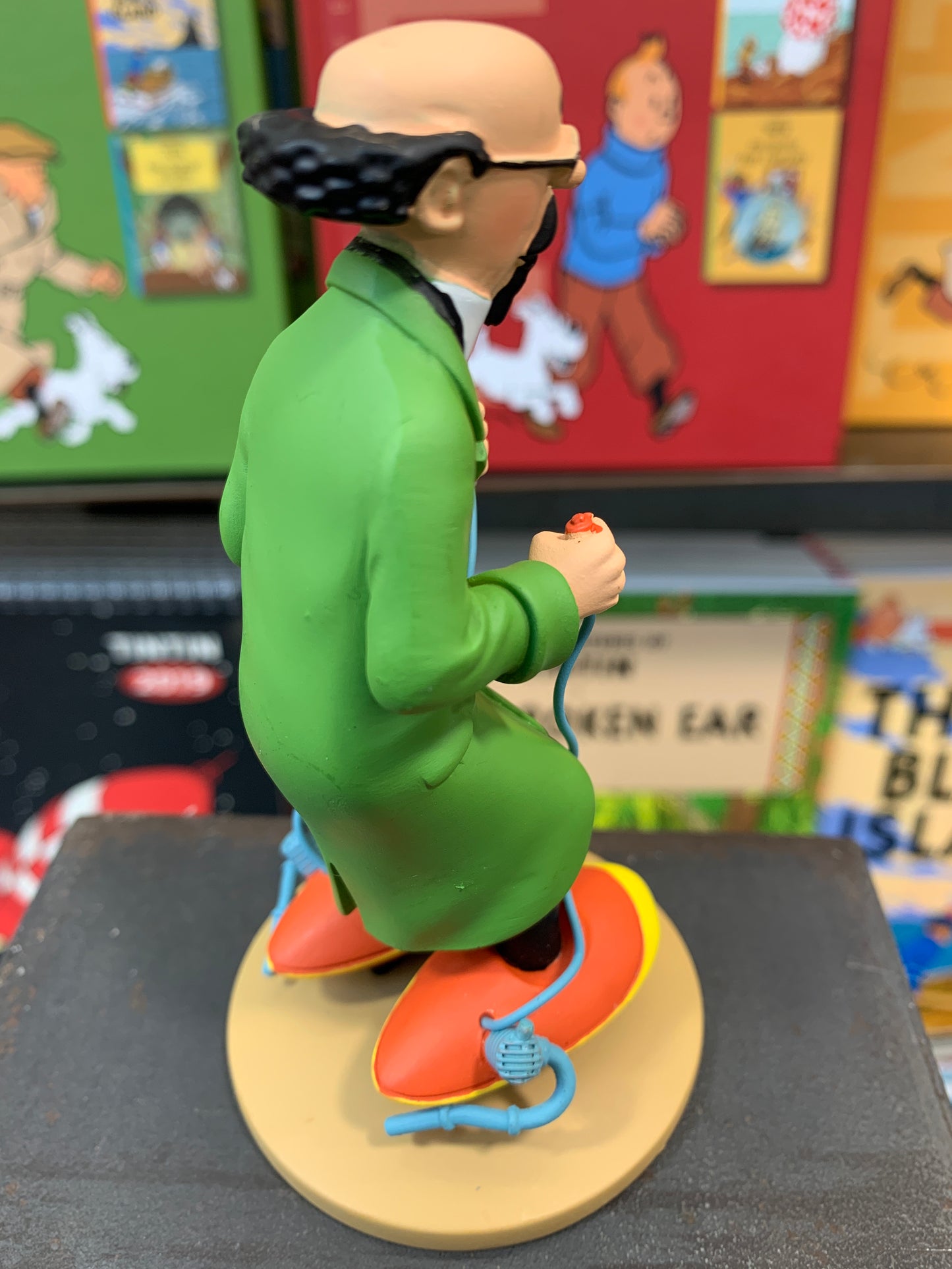 Professor Calculus resin figure wearing green coat on motorized skates, holding remote control, comic book background