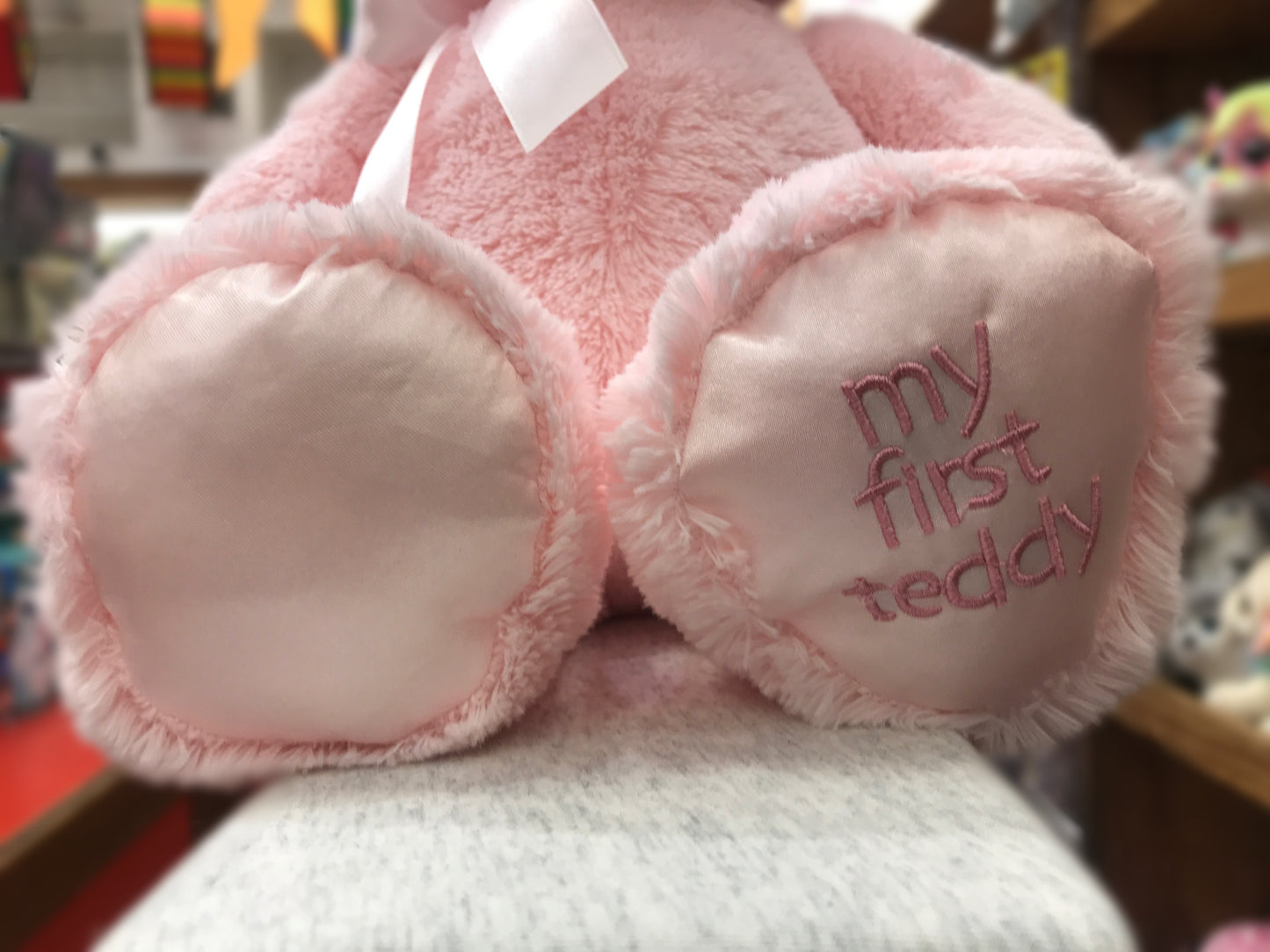Soft pink Baby Gund teddy bear with satin bow and "My First Teddy" embroidered on foot, perfect for newborns