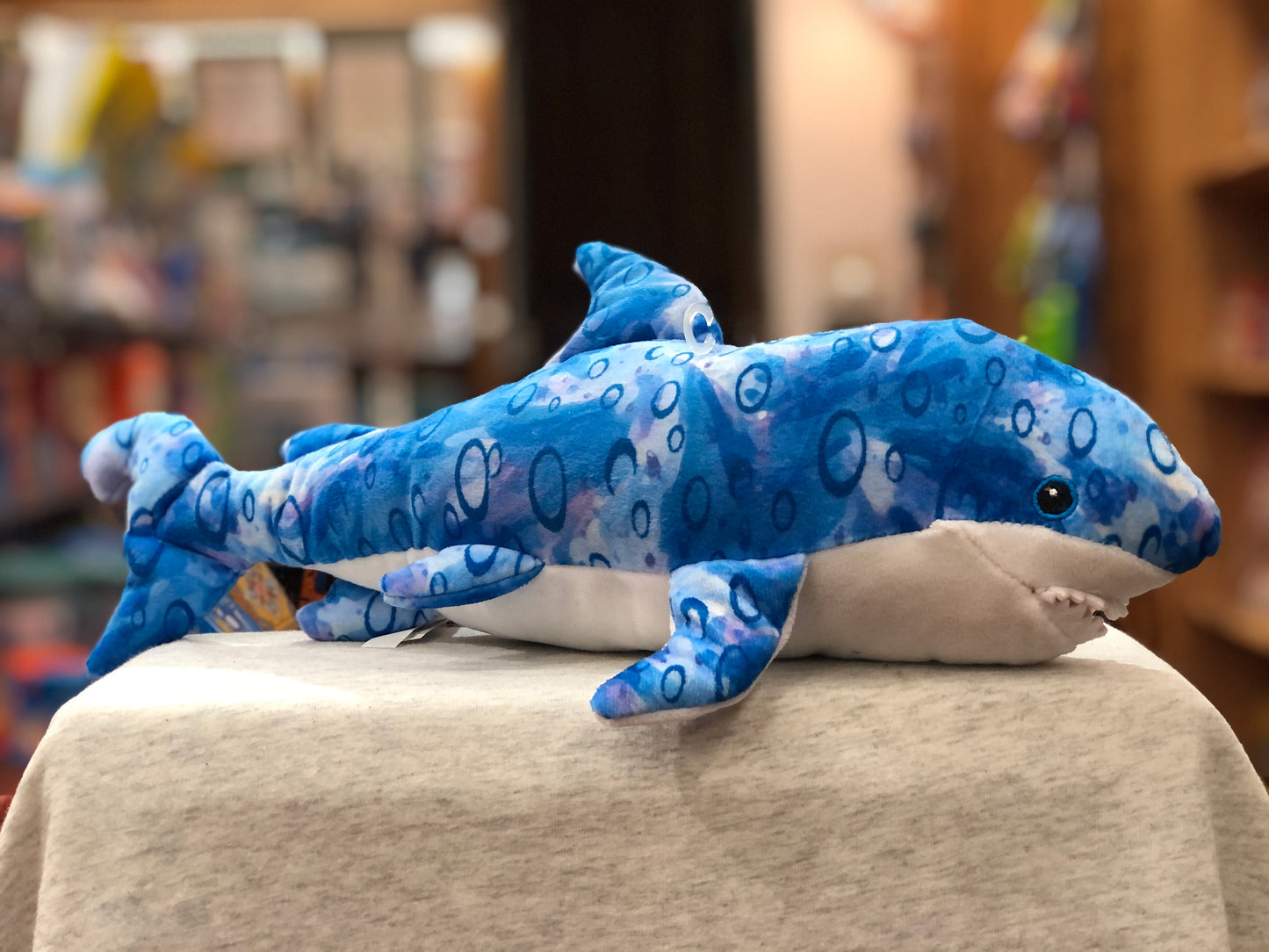 Blue shark plush toy with bubble pattern, part of Douglas Reef Green Friends collection, on display in store