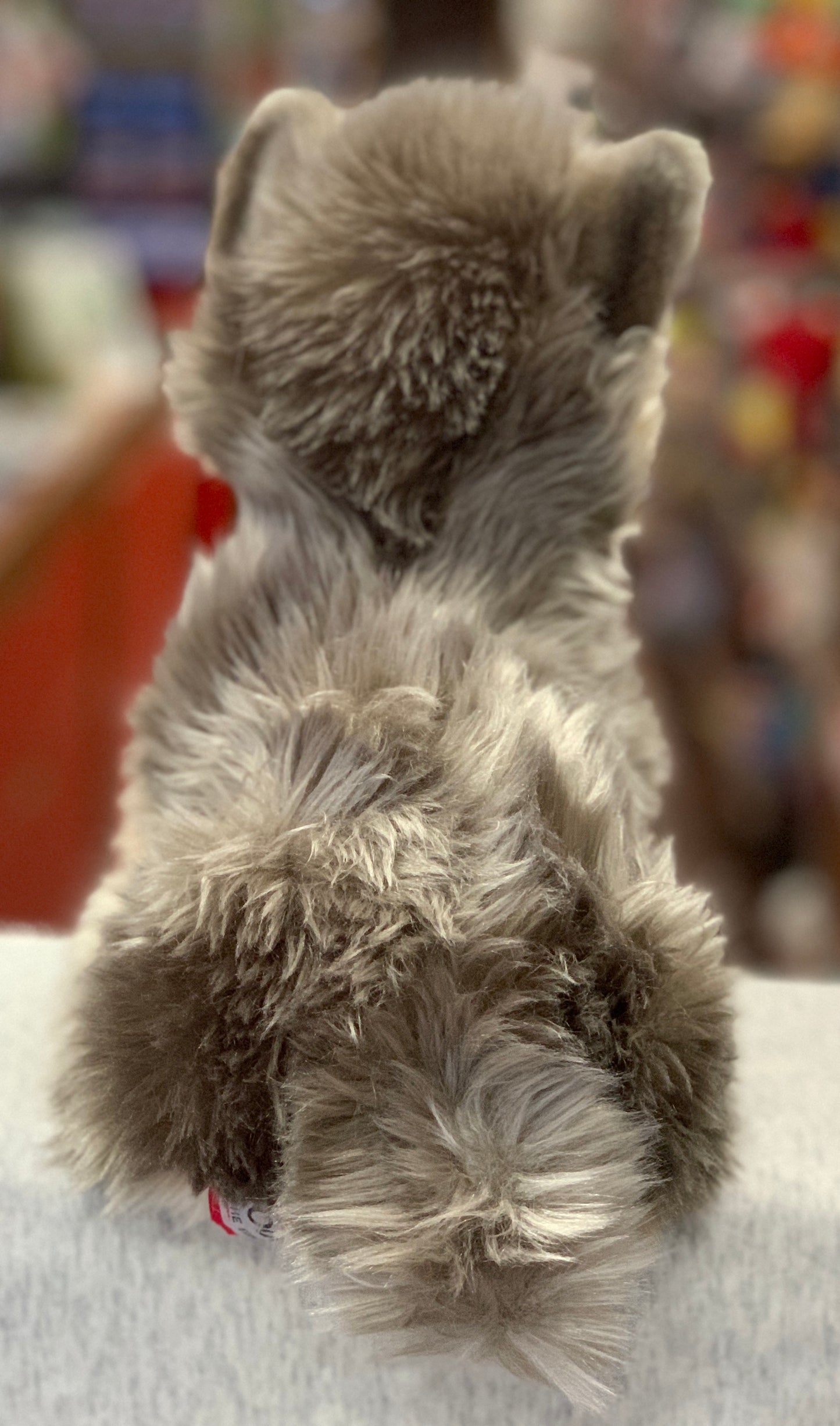 Lifelike Yorkie plush toy, Yettie, shown from behind with soft gray fur, sitting on display for Yorkshire Terrier fans