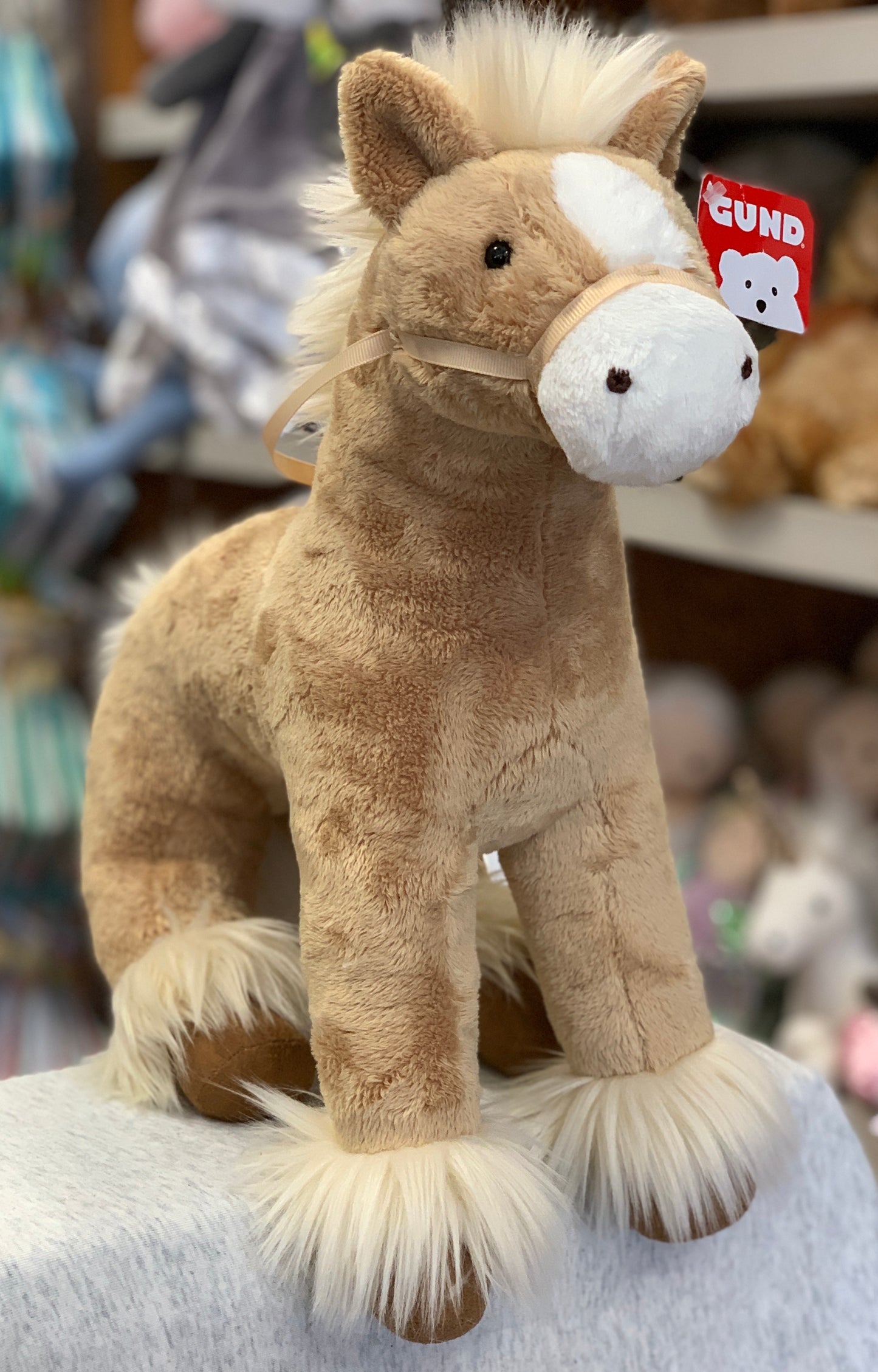 Gund Dakota 15" tan horse plush toy with white mane and tail, standing on display in store