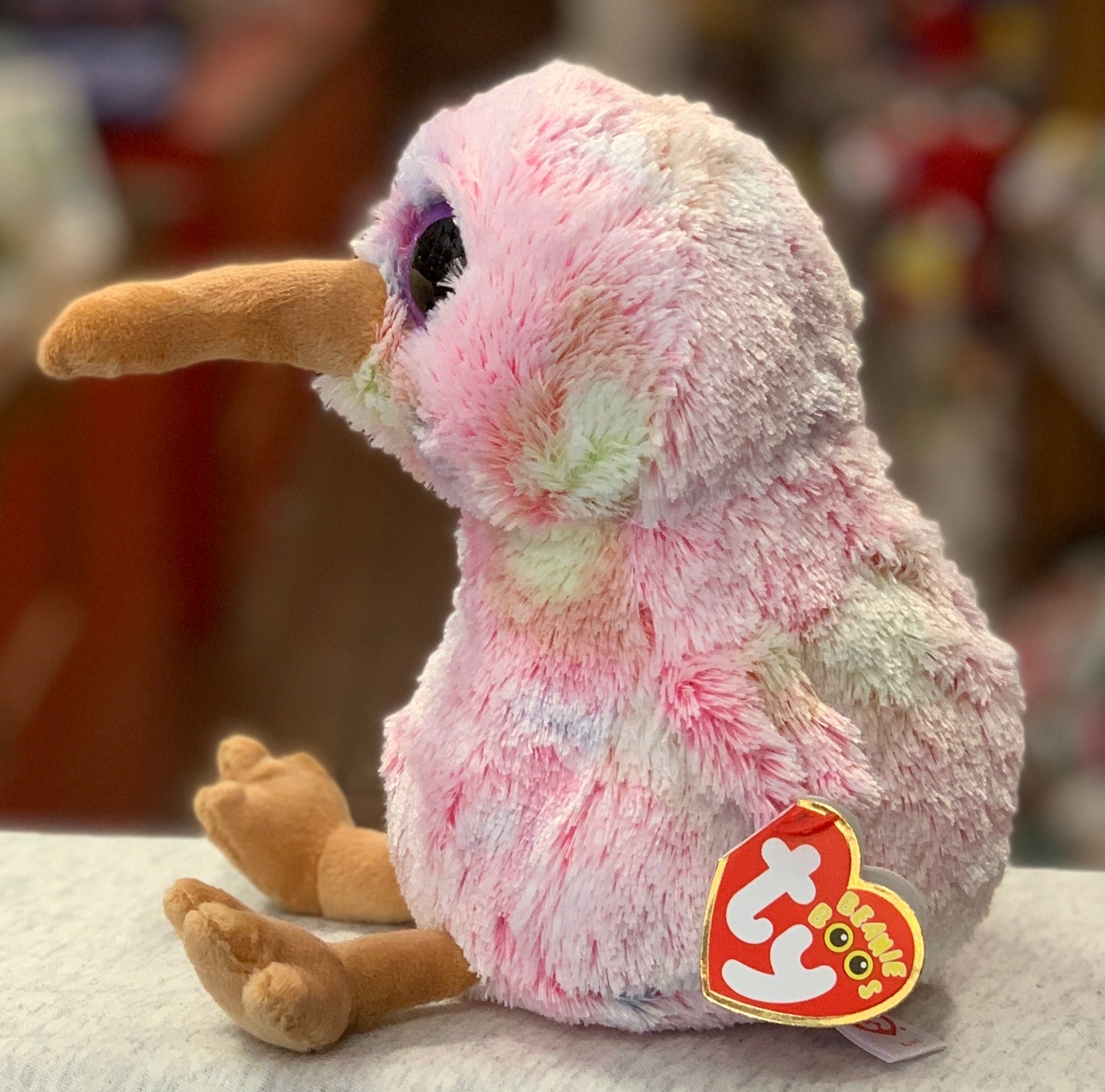 Adorable pink Ty Beanie Boo kiwi bird plush toy with large eyes, soft fur, and Ty heart tag, perfect for cuddling