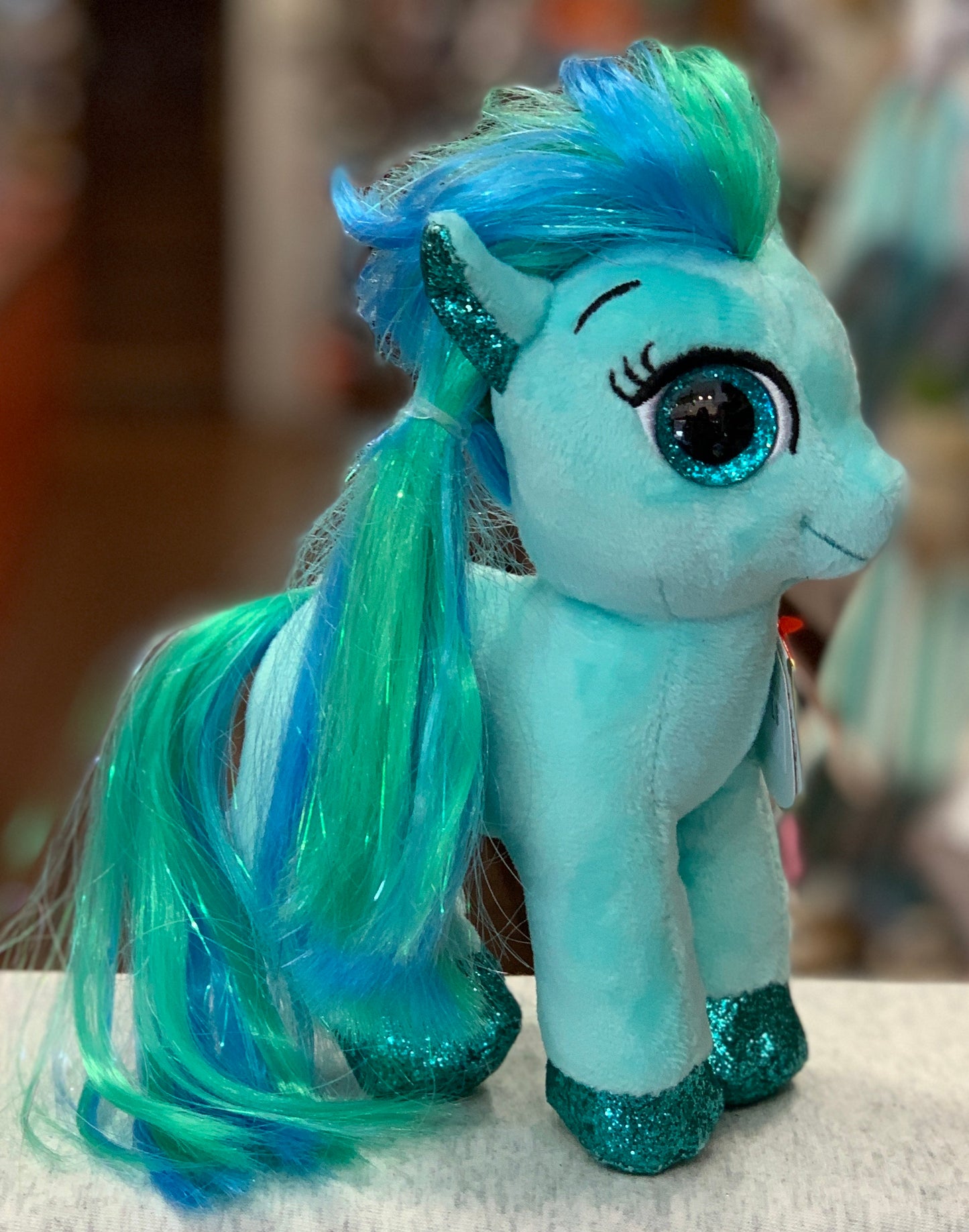 Ty Beanie Boo Topaz pony plush with blue and green sparkly mane, teal body, and glittery hooves