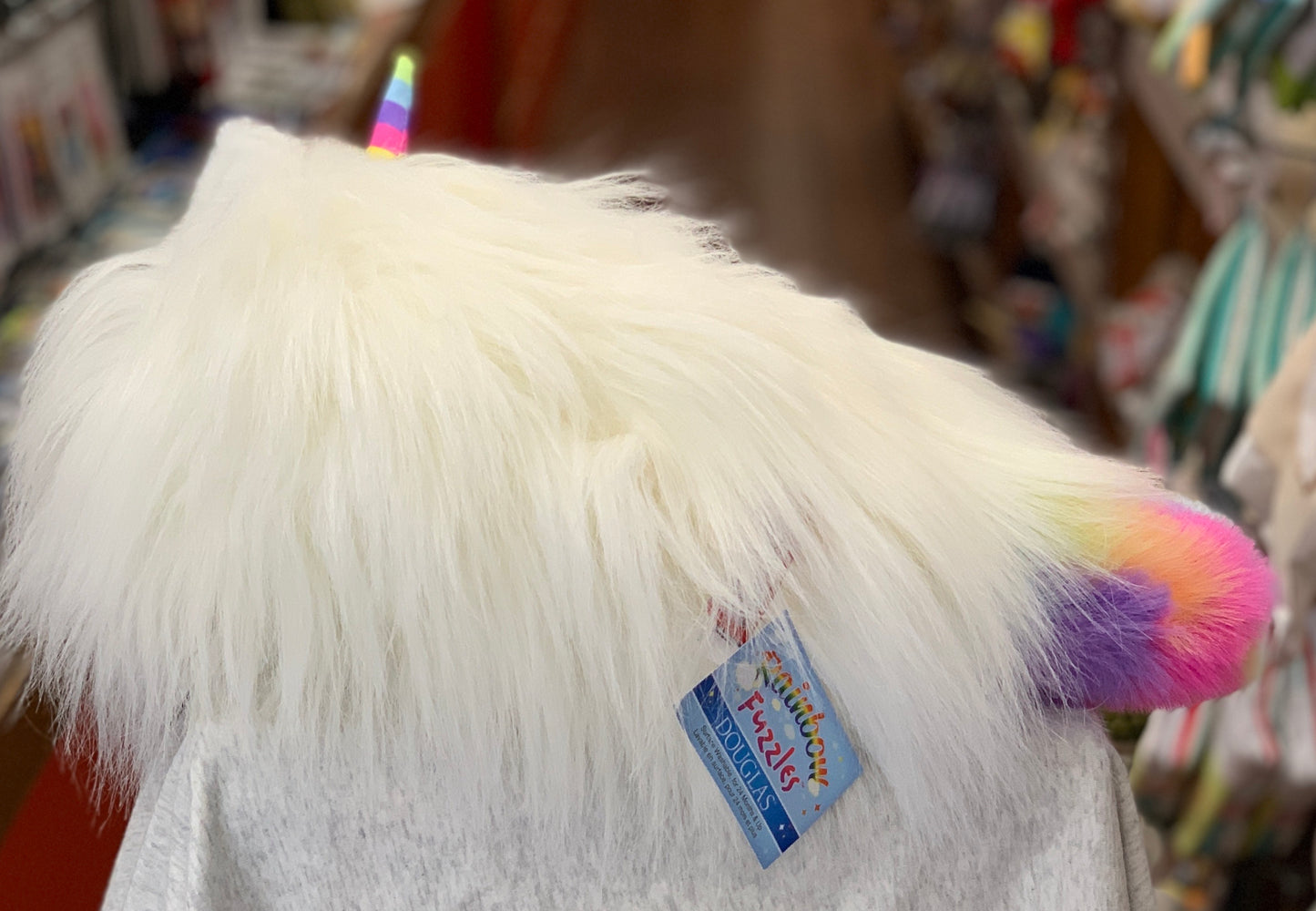 Fluffy white Rainbow Fuzzle Caticorn plush with colorful unicorn horn and tail, featuring Douglas brand tag