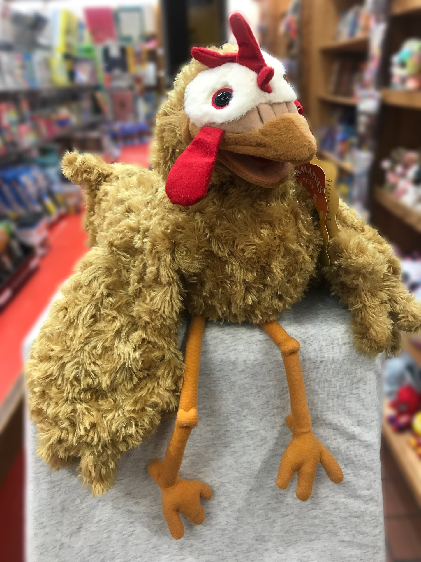 Folkmanis Chicken Puppet with fluffy brown feathers, red comb and wattle, movable beak and wings, displayed in toy store