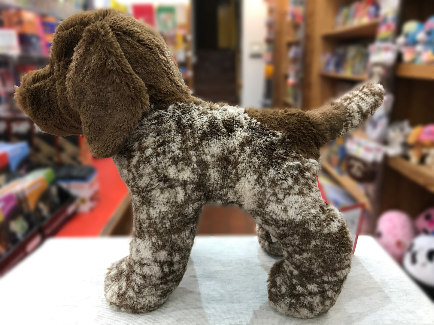 Realistic German Pointer plush dog with brown and white spotted coat, floppy ears, standing in toy store display