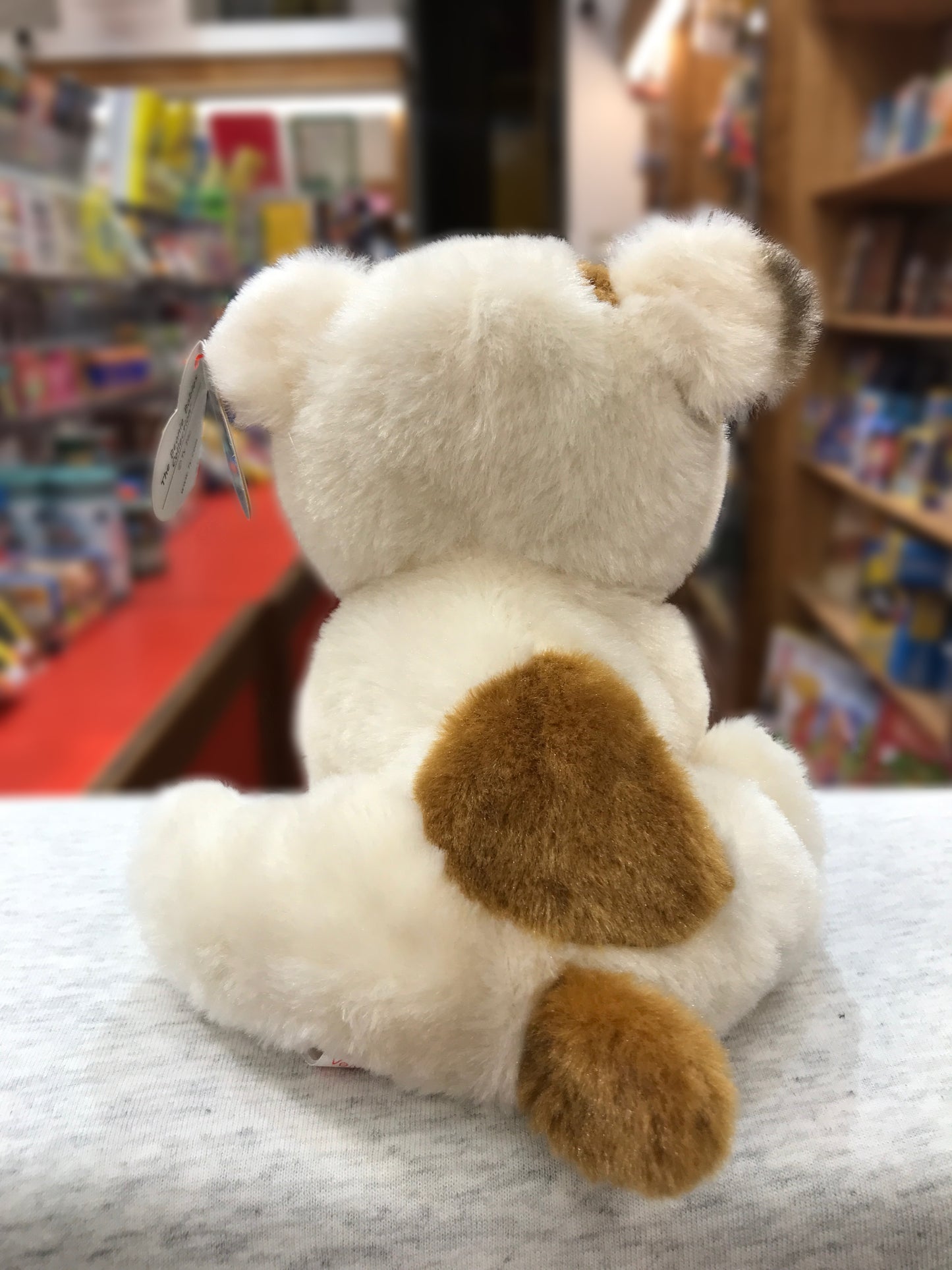 Ty Beanie Baby Houghie pug plush toy, white with tan spots, sitting in store display with tag visible
