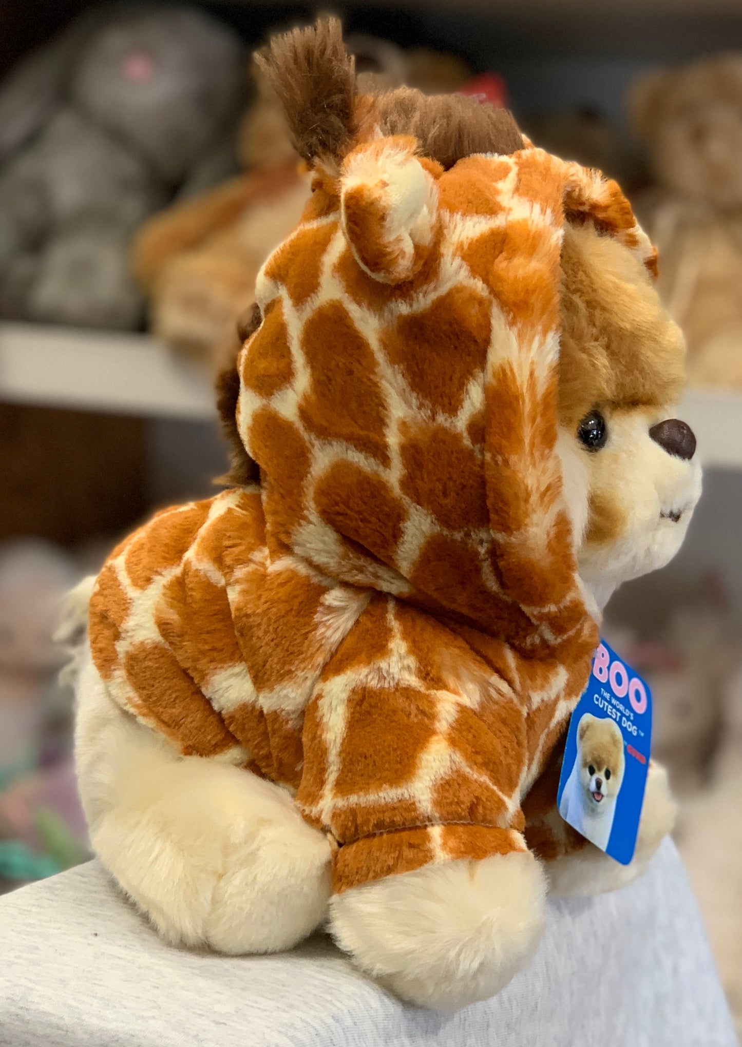 Gund plush toy of internet-famous Pomeranian Boo dressed as a giraffe, with soft orange and cream fur and blue tag