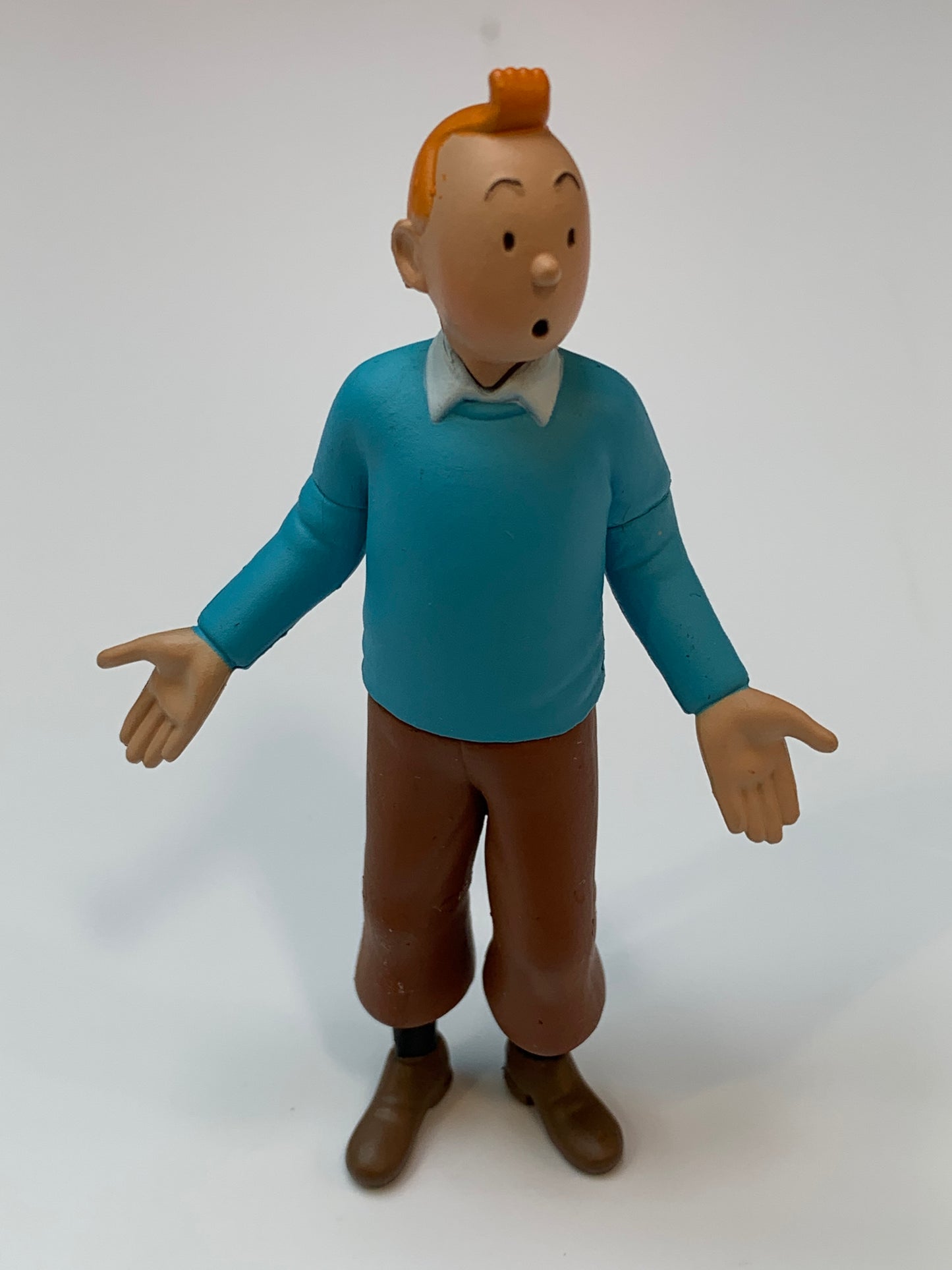Tintin mini figure in blue sweater with surprised expression, hands outstretched, 8cm tall PVC collectible