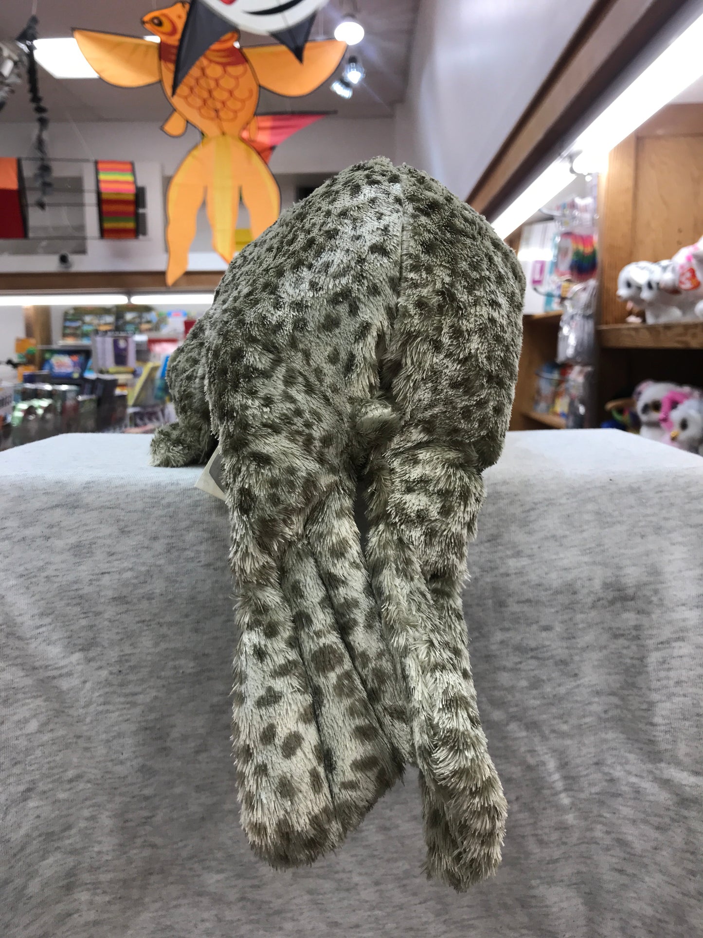 Folkmanis Harbor Seal Puppet with spotted gray fur on display in toy store, showcasing realistic texture and size