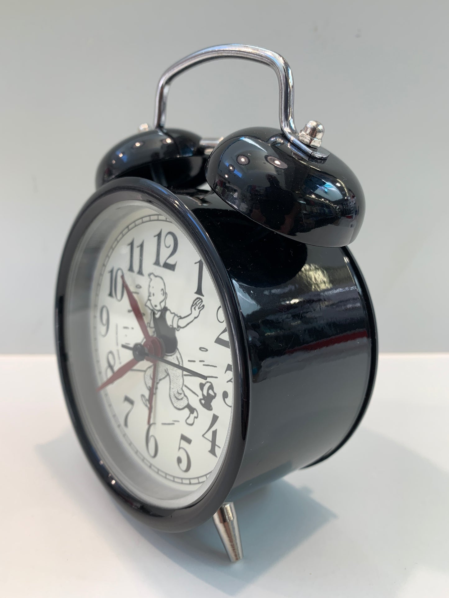 Tintin twin bell alarm clock with black metal body, featuring character illustration on white clock face