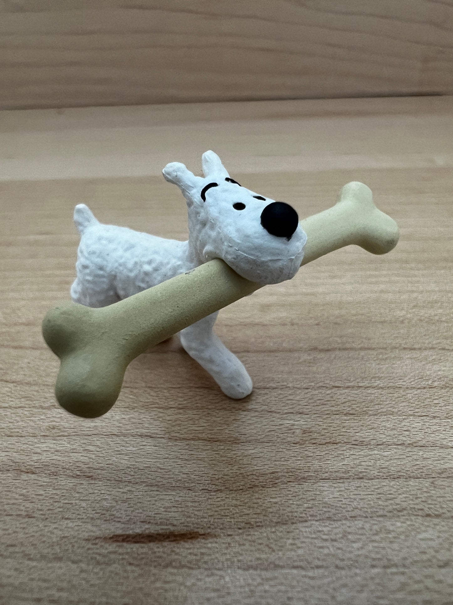 Tintin's Snowy figurine carrying oversized camel bone, from 'The Crab With Golden Claws' adventure, 6cm PVC collectible