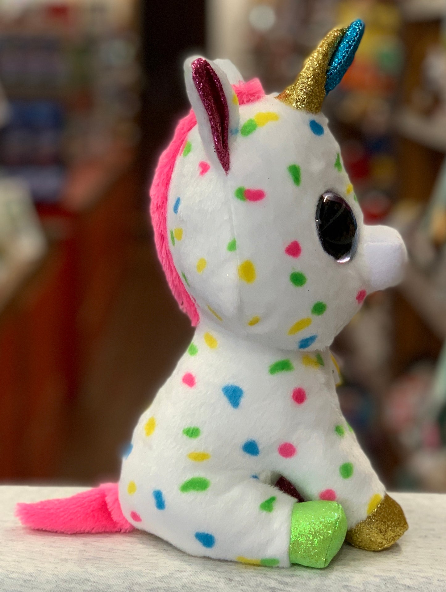 Colorful Ty Beanie Boo Harmonie unicorn plush with sparkly horn, ears, and hooves, featuring multicolored polka dots on white fur