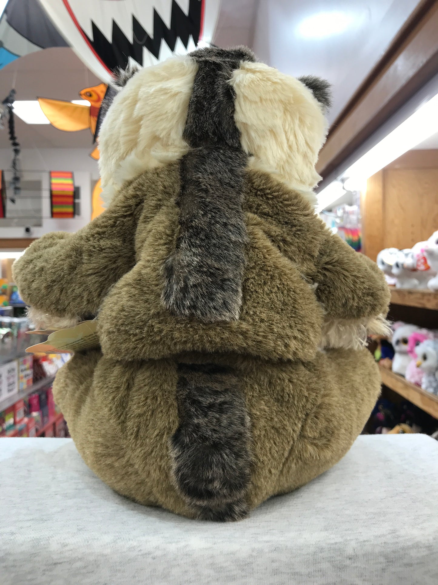 Folkmanis Slow Loris puppet in store, showing back view of plush toy with distinctive brown and white fur pattern