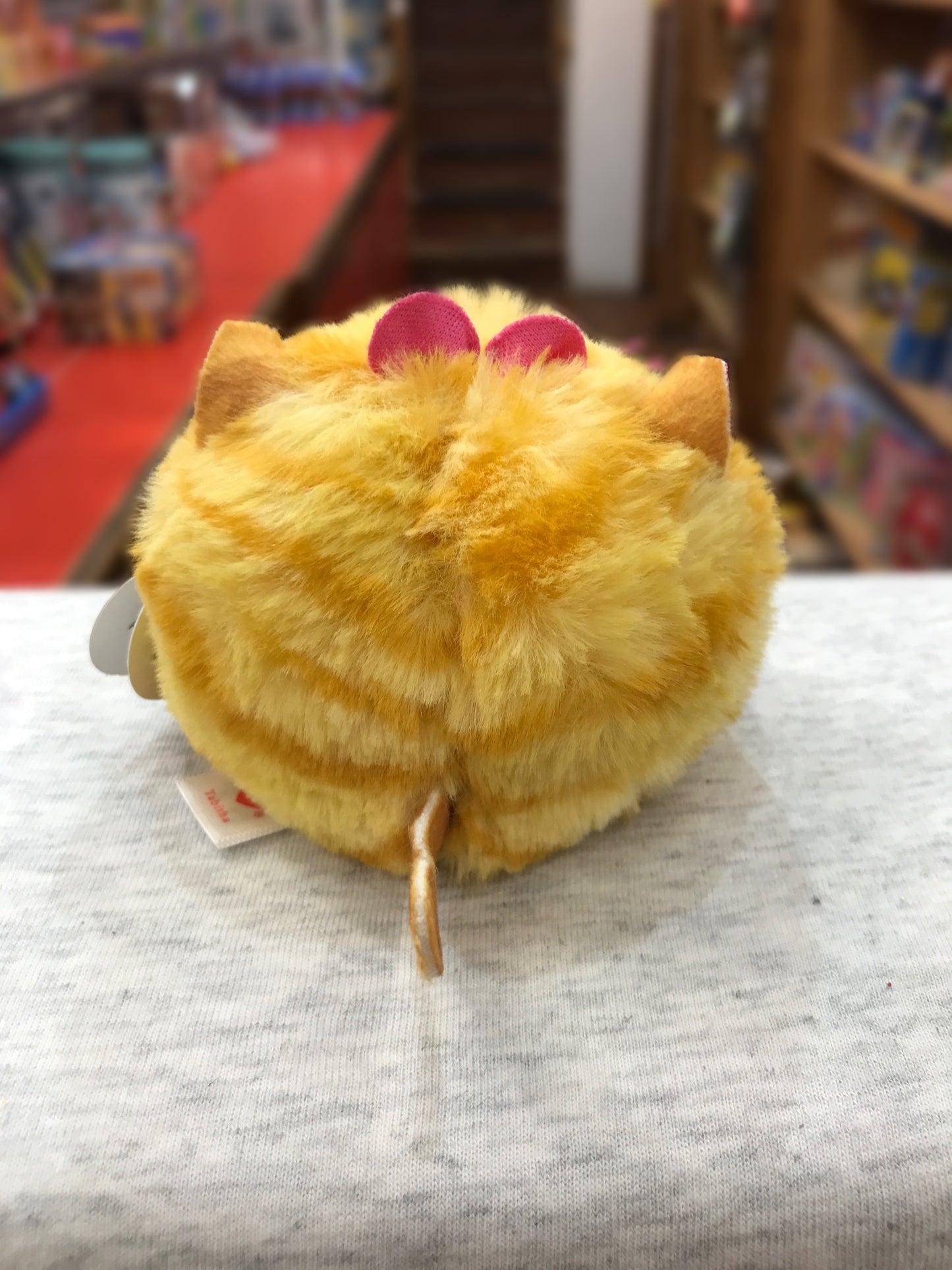 Ty Puffies Tabitha yellow cat plush toy with pink bow, round and fluffy, on display in toy store
