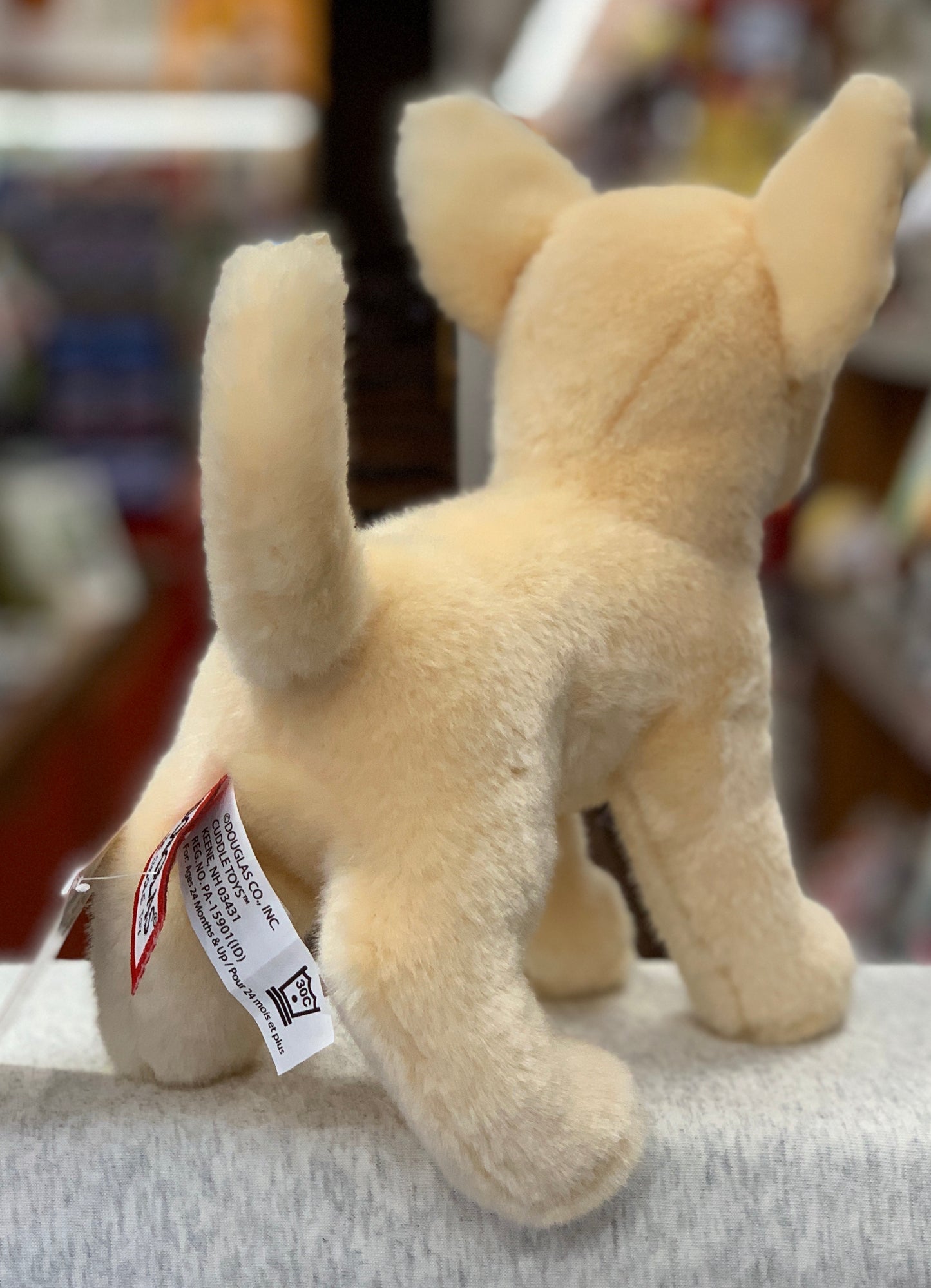 Realistic 10" plush Chihuahua dog with fawn-colored coat, large ears, and lifelike details, standing on display