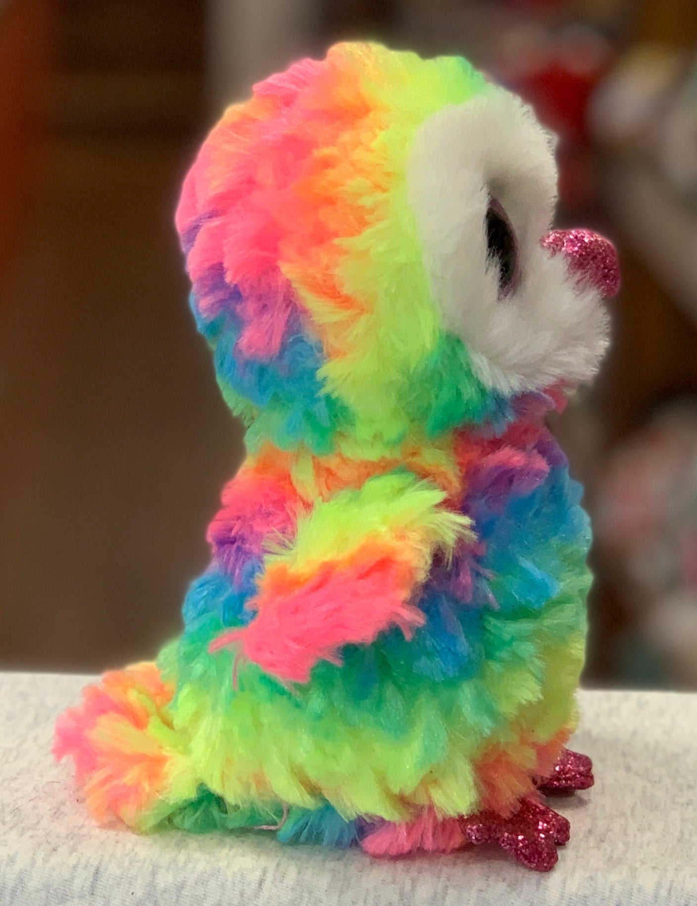 Ty Beanie Boo Owen Owl plush toy with vibrant rainbow-colored fur, white face, and sparkly pink feet and beak