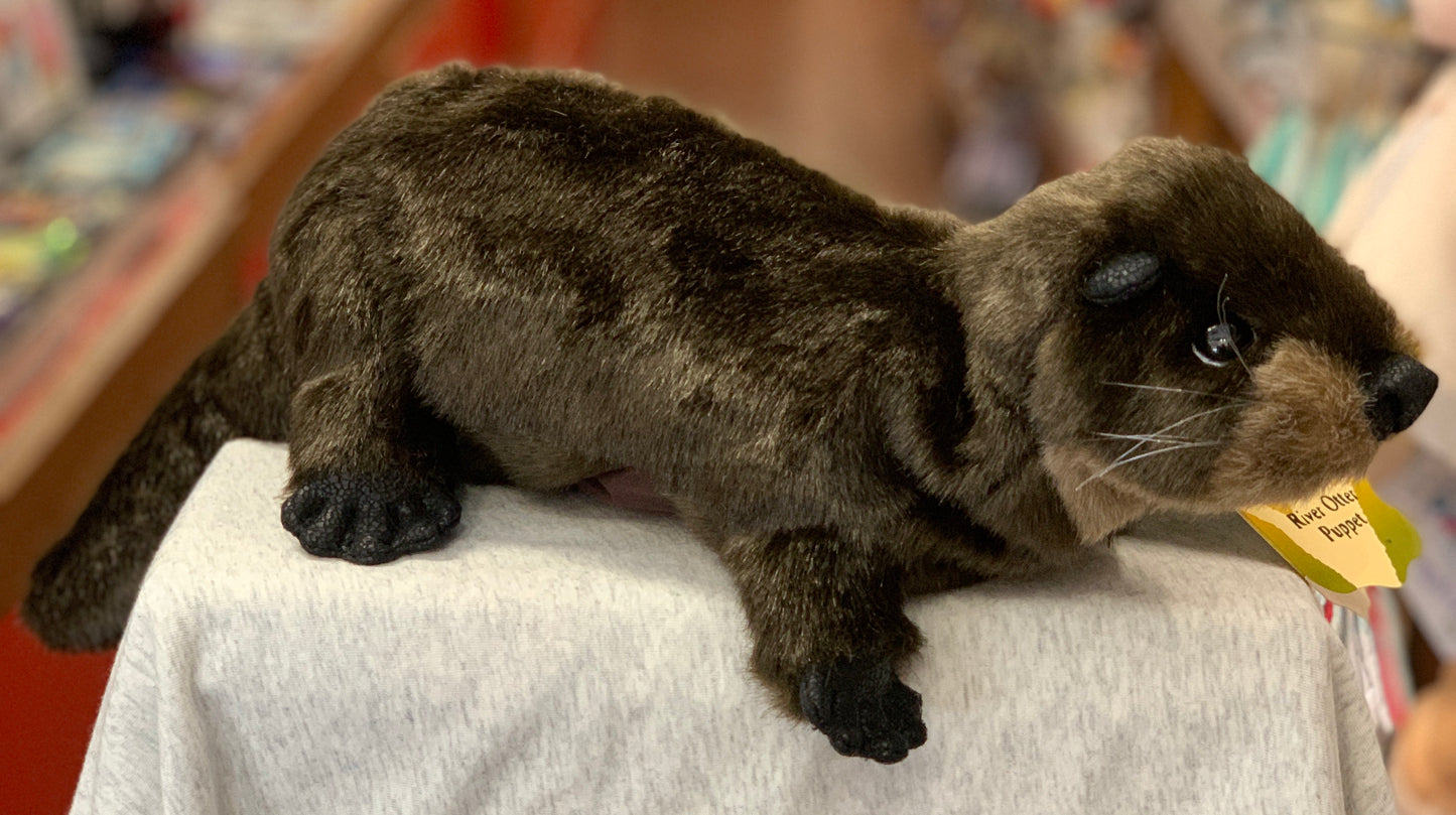 Realistic Folkmanis river otter hand puppet with chestnut fur and webbed feet, displayed on white surface