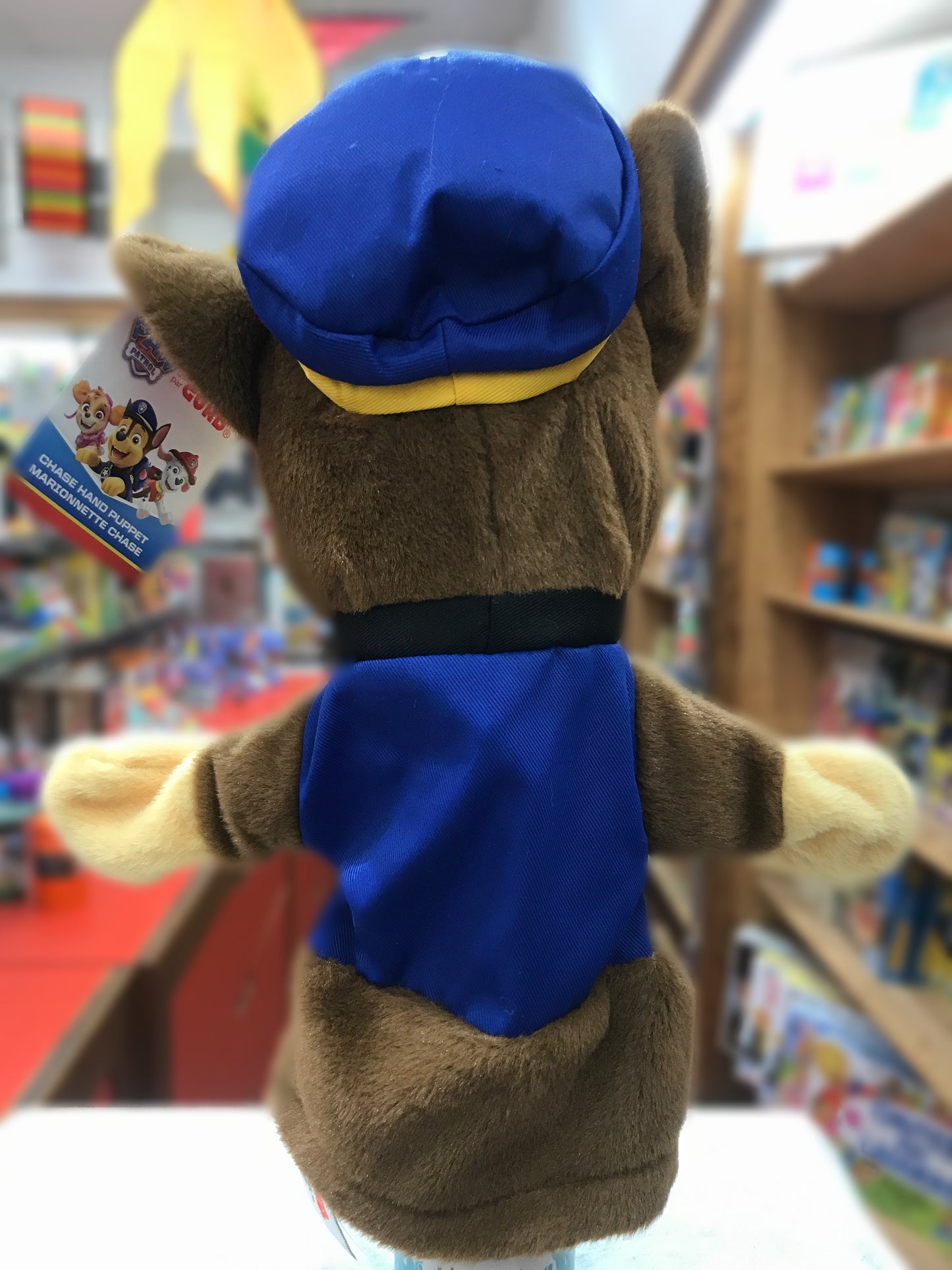 Gund Paw Patrol Chase hand puppet, soft brown plush with blue uniform and cap, displayed in toy store