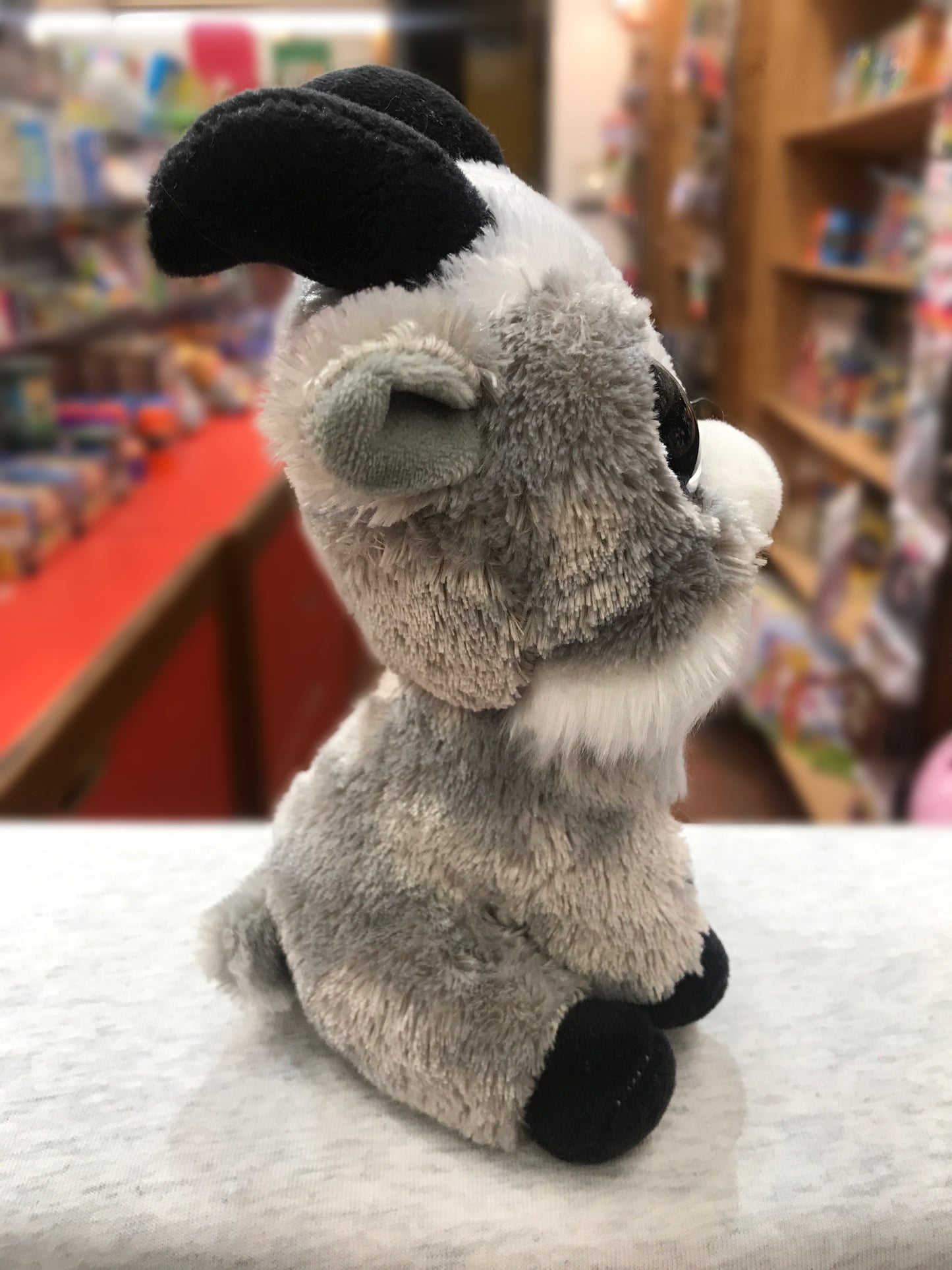 Adorable Ty Beanie Boo Gabby Goat plush toy sitting on display, with soft gray fur and large sparkly eyes