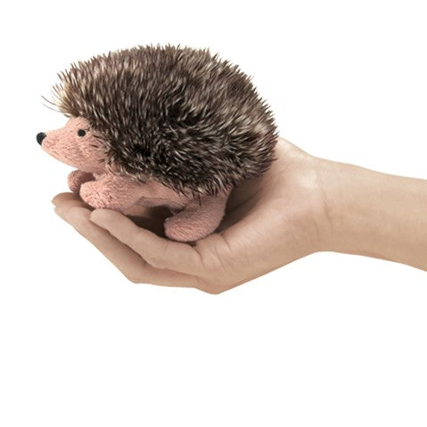 Cute plush hedgehog finger puppet with soft spines resting in an open hand, demonstrating its small 3-inch size