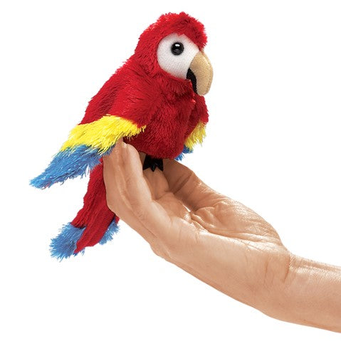 Colorful mini scarlet macaw finger puppet perched on hand, featuring vibrant red, yellow, and blue plumage
