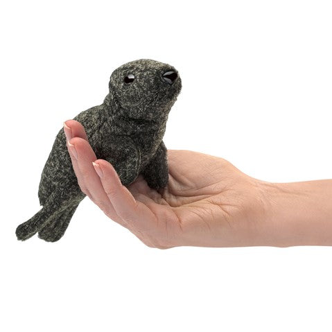 Brown speckled Folkmanis Mini Harbor Seal finger puppet held in a hand, showcasing its small 5-inch size and realistic design