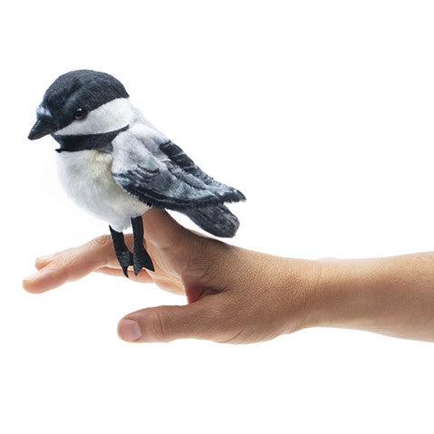 Folkmanis Mini Chickadee finger puppet perched on hand, soft fabric with realistic black, white, and gray markings