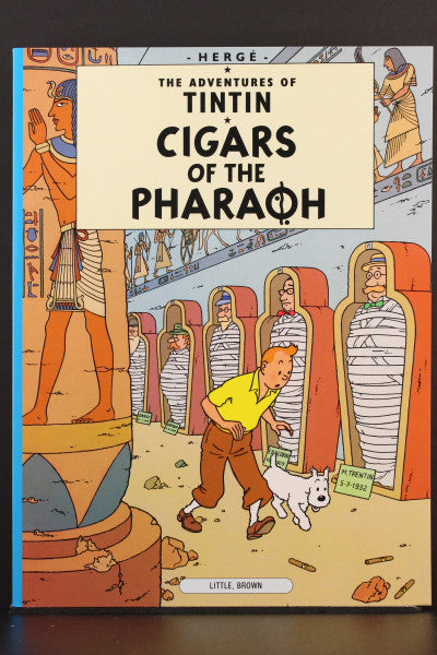 Book cover of Tintin adventure "Cigars of the Pharaoh" showing Tintin and Snowy exploring Egyptian tombs