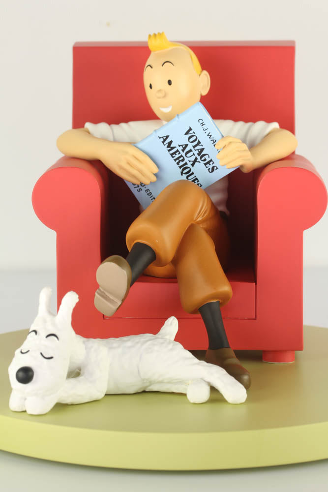 Tintin figurine reading in red chair with Snowy dog, from The Broken Ear adventure collectible resin statue