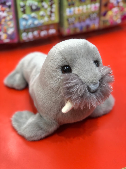 Adorable Douglas Brinie soft walrus plush toy on red background, featuring realistic gray fur, whiskers, and tusks