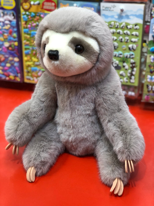 Cuddly Douglas Super Lizzie Soft Sloth plush toy with realistic features, sitting on red surface against colorful toy displays