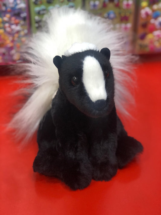 Adorable Douglas Odie skunk plush toy with black fur, white face stripe, and fluffy white tail on red background