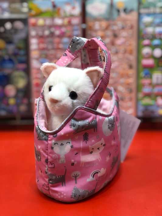 White plush cat peeking out of pink Purr-fect Pals Sassy Sak bag with cat pattern, displayed in toy store setting