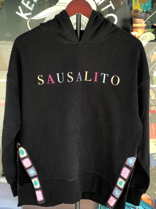 Black sweatshirt with 'SAUSALITO' text and colorful embellishments.
