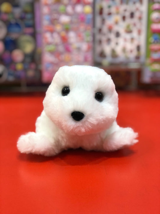 Adorable white harp seal plush toy Sprinkles on red surface, soft and huggable, perfect for all ages