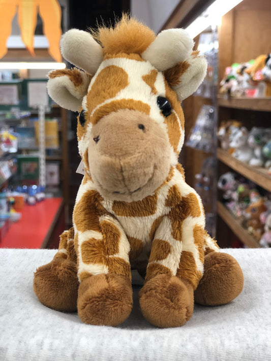 Soft and cuddly Charlie Bears giraffe plush toy for babies, featuring a smiling face and spotted pattern, displayed in a toy store